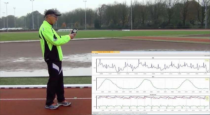 man holding smartphone on track viewing smart shirt data