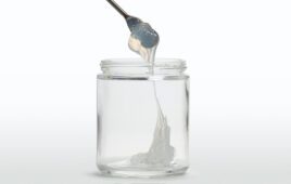Self-lubricating liquid silicone rubber dripping into a clear glass jar