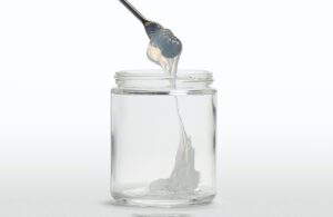 Self-lubricating liquid silicone rubber dripping into a clear glass jar