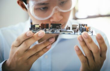 A medical device engineer holding a circuit board.