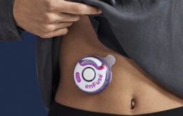 A patient wears the Enable Injections disc-shaped Enfuse device on their stomach.