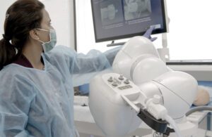 A woman performs a robotic-navigated bronchoscopy with a Noah Medical Galaxy.