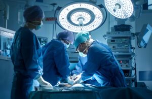 A stock photo of surgeons working on a patient in an operating room.