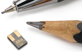 A small, flat, rectangular Stereax battery with a pencil tip and ballpoint pen for scale.