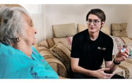 A photo of a Best Buy Geek Squad employee helping a chronic care patient with a remote monitoring device.