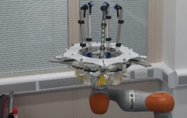 A photo of a robotic system with finger-like arms and sensors for breast exams.