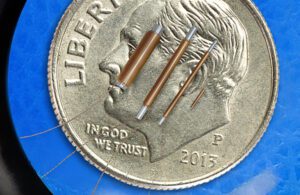 An illustration of electromagnetic sensor micro-coils on a dime for scale.