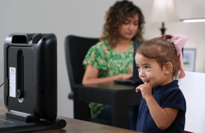 A photo of a child using the EarliTec EarliPoint device for autism diagnosis and assessment.