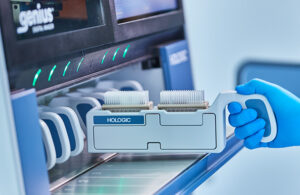 A photo of specimen slides being loaded into Hologic's Genius Digital Diagnostics System scanner.