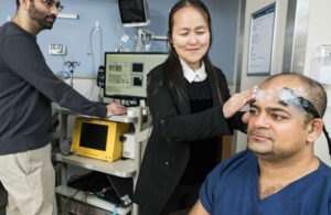 ECMO monitoring researchers Regine Choe (center), Imad Khan (right) and Irfaan Dar (left) pose with diffuse correlation spectroscopy (DCS) sensors that noninvasively measure brain-blood flow.