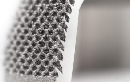 A titanium 3D printing close-up showing the complex surface geometry of an orthopedic implant.