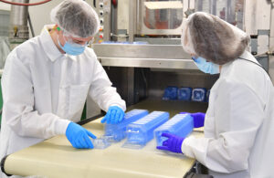 A photo of Plastic Ingenuity team members inspecting thermoform parts in an ISO Class 8 clean room.