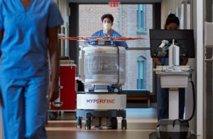 A photo of a Hyperfine Swoop MRI scanner being pushed down the hall of a hospital.