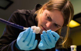 A photo of Capstan Medical Head of Delivery Systems and Accessories Evelyn Haynes works on the device developer's catheter-delivered heart valve implant.