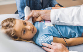 A photo of a noninvasive diagnostic device being used on a child.