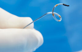A photo of Medtronic's Symplicity Spyral renal denervation catheter with a gloved hand for scale.