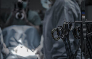 This is an Unsplash image of surgical tools in the foreground of a surgery to go along with a story about a Stanford Medical hydrogel to prevent surgical adhesions.
