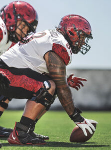 A photo of a football player wearing Enovis DonJoy Defiance Pro knee braces.