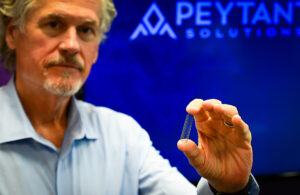 An image of Peytant Solutions CEO John Schorgl holding the AMStent device.