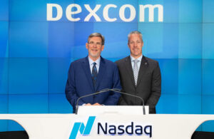 A photo of Dexcom President and CEO Jacob Leach and former Dexcom CEO and now-Executive Chair Kevin Sayer in front of a desk that says Nasdaq.