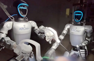 A photo of two humanoid robots performing a surgery.