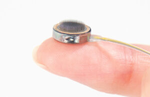 A photo of the Paradromics Connexus brain-computer interface on a fingertip.