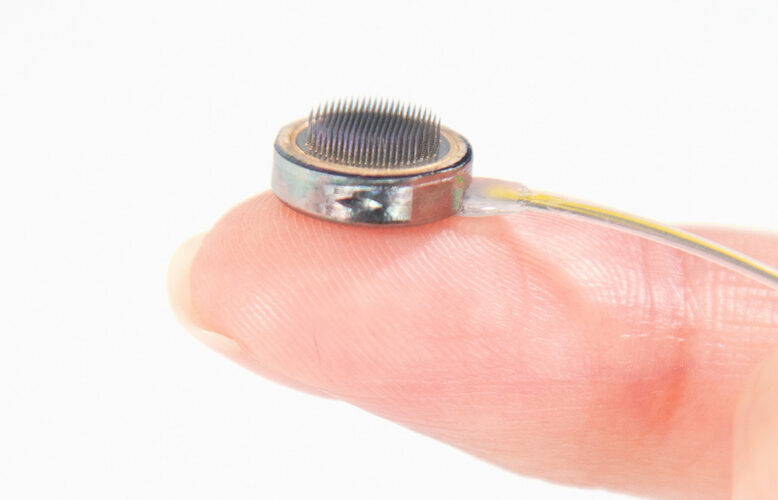 A photo of the Paradromics Connexus brain-computer interface on a fingertip.