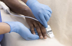 A photo of BD's VitaWave Plus finger cuff on a patient.